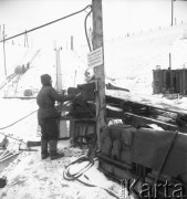 Luty 1958, Tarnobrzeg, Polska.
Budowa pierwszej odkrywkowej kopalni siarki, robotnik przy taśmociągu. Napis nad urządzeniem: 