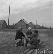 Kwiecień 1958, Jackowice, woj. Łódź, Polska.
Wiejskie dzieci bawią się z psem, w tle domy.
Fot. Romuald Broniarek, zbiory Ośrodka KARTA