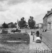 Maj 1958, Lesko, Polska.
Fragment miasteczka, na pierwszym planie kobieta z wózkiem i dwie dziewczynki.
Fot. Romuald Broniarek, zbiory Ośrodka KARTA