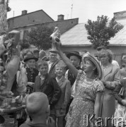 Czerwiec 1958, Łowicz, Polska.
Odpustowy stragan - kobieta demonstruje glinianego bociana.
Fot. Romuald Broniarek, zbiory Ośrodka KARTA