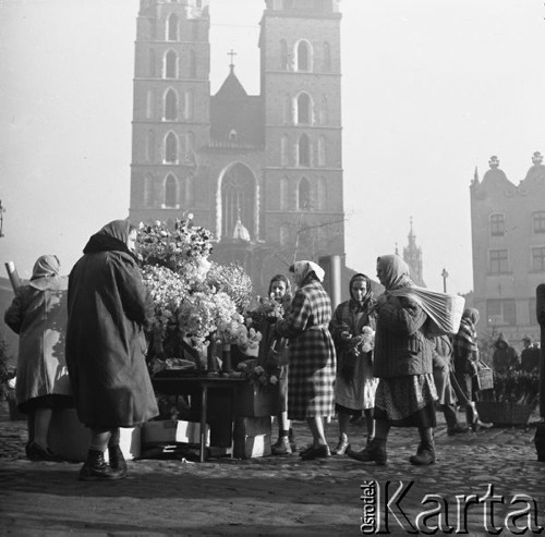 Grudzień 1958, Kraków, Polska.
Kwiaciarki na Rynku, w tle kościół Mariacki.
Fot. Romuald Broniarek, zbiory Ośrodka KARTA