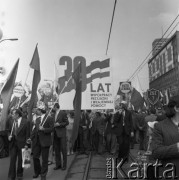 1.05.1975, Warszawa, Polska. 
Obchody święta 1 Maja, uczestnicy pochodu przechodzą ulicą Marszałkowską niosąc flagi i hasło: 