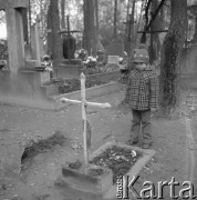 Listopad 1975, Warszawa, Polska.
Jeden z warszawskich cmentarzy - dziecko stojące obok dziecięcego grobu.
Fot. Romuald Broniarek/KARTA