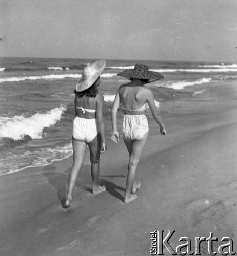 Lipiec 1959, Jastarnia, Polska.
Wypoczynek nad Bałtykiem - dwie kobiety w kapeluszach i strojach kąpielowych idą brzegiem morza.
Fot. Romuald Broniarek/KARTA