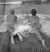 Lipiec 1959, Jastarnia, Polska.
Wypoczynek nad Bałtykiem - dwie kobiety w strojach kąpielowych leżą na brzegu morza.
Fot. Romuald Broniarek/KARTA