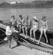 Sierpień 1959, Sandomierz, Polska.
Międzynarodowy obóz studencki - dziewczyny i chłopcy siedzą na burcie statku, dwaj chłopcy grają na gitarach.
Fot. Romuald Broniarek/KARTA