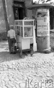 Sierpień 1959, Sandomierz, Polska.
Chłopiec stojący przed wózkiem lodziarza, na słupie wisi afisz informujący o spektaklu 