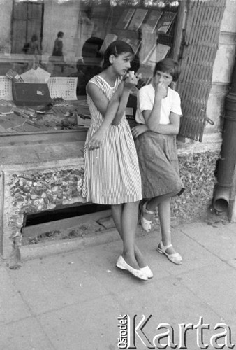 Sierpień 1959, Sandomierz, Polska.
Dwie dziewczynki stoją przed witryną sklepu papierniczego.
Fot. Romuald Broniarek/KARTA