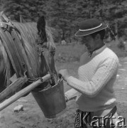 Lipiec 1977, Poronin, Polska.
Góral pojący konia wodą z wiadra.
Fot. Romuald Broniarek/KARTA