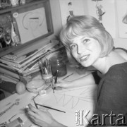 1959, Polska. 
Młoda kobieta rysująca choinkę, na ścianie wiszą projekty damskich ubrań.
Fot. Romuald Broniarek/KARTA
