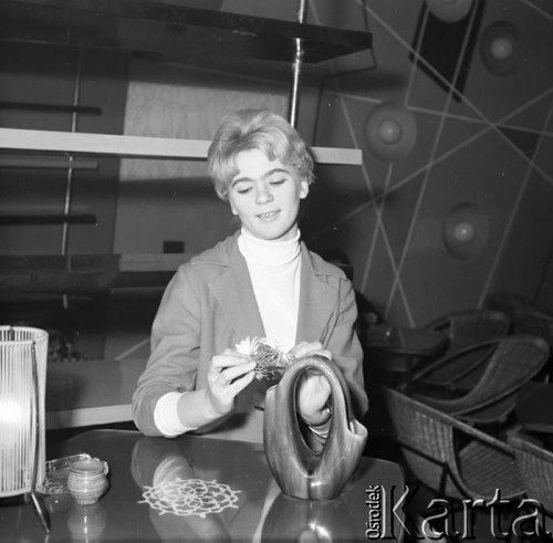 Luty 1960, Łódź, Polska.
Klub studencki - dziewczyna wkłada kwiaty do wazonu.
Fot. Romuald Broniarek/KARTA