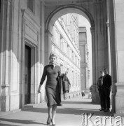 Marzec 1960, Kraków Nowa Huta, Polska.
Kobieta przechodzi pod arkadami budynku, z prawej stoją dwaj chłopcy.
Fot. Romuald Broniarek/KARTA