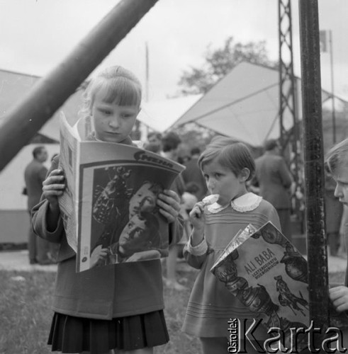 Maj 1961, Warszawa, Polska.
Kiermasz książki w Alejach Ujazdowskich, dziewczynka z radzieckim pismem 