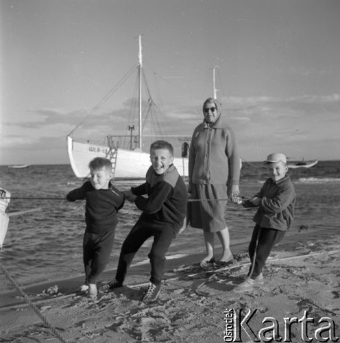 Lipiec 1961, Polska.
Trzej chłopcy ciągną łódź, w tle kuter rybacki.
Fot. Romuald Broniarek/KARTA