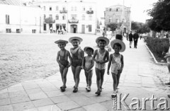 Lipiec 1961, Chełm, Polska.
Fragment miasta, pięcioro dzieci w kapeluszach idzie ulicą.
Fot. Romuald Broniarek/KARTA