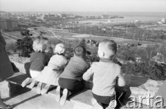 Maj 1962, Gdynia, Polska.
Na pierwszym planie dzieci siedzące na ławce, w tle panorama portu.
Fot. Romuald Broniarek/KARTA
