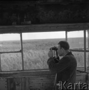 Lipiec 1962, Kętrzyn (okolice), Polska.
Leśniczy obserwuje las przez lornetkę z ambony.
Fot. Romuald Broniarek/KARTA