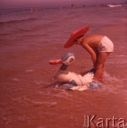 Lipiec 1963, Krynica Morska, Polska.
Chłopiec w kapeluszu kąpie się w morzu razem z nadmuchiwaną kaczką.
Fot. Romuald Broniarek/KARTA