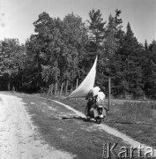 Sierpień 1964, Mazury, Polska.
Mężczyzna i chłopiec jadą polną drogą na motorowerze z żaglem.
Fot. Romuald Broniarek/KARTA