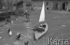 Sierpień 1964, Mazury, Polska.
Mężczyzna w żaglówce stojącej na podwórku.
Fot. Romuald Broniarek/KARTA