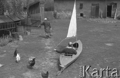 Sierpień 1964, Mazury, Polska.
Mężczyzna w żaglówce stojącej na podwórku.
Fot. Romuald Broniarek/KARTA