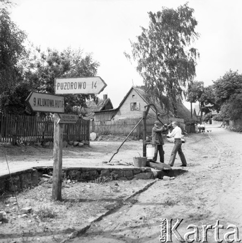 Lipiec 1965, Sulęczyno, Polska.
Dwaj mężczyźni pompują wodę ze studni.
Fot. Romuald Broniarek/KARTA