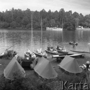 Lipiec 1965, Mazury, Polska.
Biwak nad jeziorem, na pierwszym planie trzy namioty i żaglówki cumujące przy brzegu.
Fot. Romuald Broniarek/KARTA