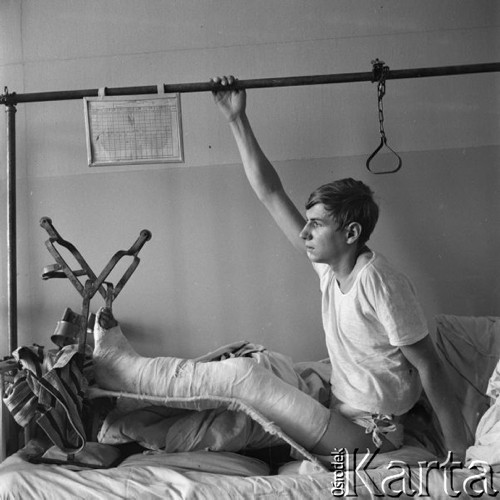 Kwiecień 1966, Warszawa, Polska.
Oddział ortopedyczny w szpitalu, chłopak z nogą w gipsie siedzi na łóżku.
Fot. Romuald Broniarek/KARTA