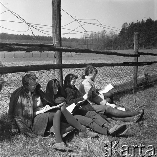 Maj 1965, Polska.
Cztery kobiety czytają gazety i książki siedząc pod płotem.
Fot. Romuald Broniarek/KARTA