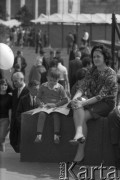 Maj 1967, Warszawa, Polska.
Kiermasz książki przed Pałacem Kultury i Nauki, na zdjęciu kobieta z chłopcem, który trzyma książkę i balonik.
Fot. Romuald Broniarek/KARTA