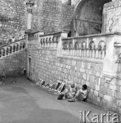 Sierpień 1967, Dubrownik, Jugosławia
Pamiątki dla turystów - dwie osoby z obrazkami siedzą pod murem.
Fot. Romuald Broniarek/KARTA