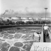Wrzesień 1967, Schwedt, Niemiecka Republika Demokratyczna (NRD)
Pracownik rafinerii na kładce nad zbiornikiem z płynem, w tle pociąg towarowy.
Fot. Romuald Broniarek/KARTA