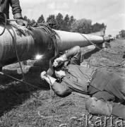 Wrzesień 1967, Lipsk (okolice), Niemiecka Republika Demokratyczna (NRD)
Polscy robotnicy z przedsiębiorstwa Hydrobudowa-6 budują rurociąg w okolicach Lipska, na zdjęciu spawacze. 
Fot. Romuald Broniarek/KARTA