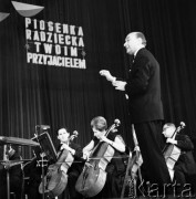 Październik 1967, Warszawa, Polska.
Koncert laureatów festiwalu piosenki radzieckiej, orkiestrą dyryguje Stefan Rachoń. Hasło w tle: 