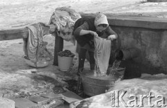 Luty 1969, brak miejsca, Lubelszczyzna, Polska.
Kobieta piorąca przy studni.
Fot. Romuald Broniarek/KARTA