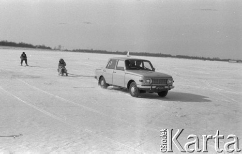 Luty 1969, Zalew Zegrzyński, Polska.
Dzieci jadą na sankach i nartach za samochodem.
Fot. Romuald Broniarek/KARTA