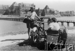 Przed 1954, Malbork, Polska.
Adam Śmietański obok motocykla z przyczepą, w której siedzi młoda kobieta, w tle zamek krzyżacki.
Fot. NN, zbiory Ośrodka KARTA, udostępniła Danuta Śmietańska.