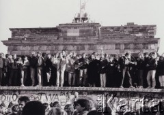 10.11.1989, Berlin, Niemcy.
Upadek Muru Berlińskiego, demonstranci na murze, w tle fragment Bramy Brandenburskiej.
Fot. Jerzy Patan, zbiory Ośrodka KARTA, przekazał Jerzy Patan.
