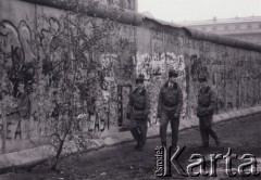 Listopad 1989, Berlin, Niemcy.
Upadek Muru Berlińskiego, trzej niemieccy żołnierze idący wzdłuż muru.
Fot. Jerzy Patan, zbiory Ośrodka KARTA, przekazał Jerzy Patan.

