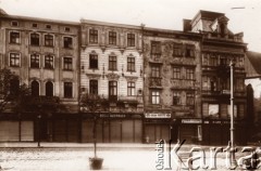 Przed 1914, Lwów, Austro-Węgry.
Południowa pierzeja Rynku, w głębi fragment Katedry Łacińskiej, szyldy sklepów i zakładów usługowych: 