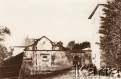 Ok. 1890, Świrz, Austro-Węgry.
Brama wjazdowa na dziedziniec gosPodarczy zamku w Świrzu. Z prawej mężczyźni na ławce, w środku siedzi austriacki policjant.
Fot. NN, zbiory Ośrodka KARTA
   

