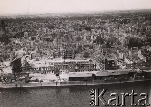 Po 1943, Magdeburg, Niemcy.
Widok z góry na miasto zniszczone po bombardowaniu - na pierwszym planie widoczne są uszkodzone magazyny usytuowane w okolicach rzeki Łaby. W oddali widoczne są ruiny zabudowy miejskiej.
Fot. NN, zbiory Ośrodka KARTA, udostępnili Katarzyna i Tomasz Krzywiccy
