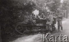 1940, Francja.
 Żołnierze Wehrmachtu stoją przy zdobytym francuskim ciągniku artyleryjskim Renault UE 1931, na pierwszym planie kapral, który ma założone na pasie austriackie ładownice do Manlichera a nie regulaminowe niemieckie do Mausera.
 Fot. NN, zbiory Ośrodka KARTA, udostępnił Stanisław Blichiewicz
   
