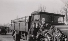 1940, Francja.
 Dwaj żołnierze Wehrmachtu przy francuskim samochodzie ciężarowym, żołnierz leżący na błotniku samochodu ma założony francuski płaszcz wojskowy. Na drugim planie niemiecki samochód Opel.
 Fot. NN, zbiory Ośrodka KARTA, udostępnił Stanisław Blichiewicz
   
