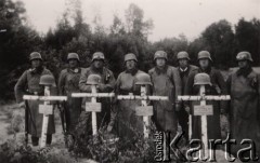 Czerwiec 1940, Francja.
 Motocykliści – żołnierze Wehrmachtu stoją przy czterech mogiłach żołnierzy niemieckich, na krzyżach powieszone hełmy, żołnierze stojący od lewej trzymają karabiny typu Mauser.
 Fot. NN, zbiory Ośrodka KARTA, udostępnił Stanisław Blichiewicz
   
