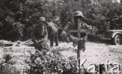 Czerwiec 1940, Francja.
 Grzebanie poległych żołnierzy Wehrmachtu, hełm na krzyżu.
 Fot. NN, zbiory Ośrodka KARTA, udostępnił Stanisław Blichiewicz
   
