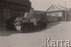 1941, ZSRR.
 Żołnierz Wehrmachtu stoi przed  radzieckim czołgiem T-34/76 a, na drugim planie widoczny żołnierz niemiecki filmujący czołg.
 Fot. NN, zbiory Ośrodka KARTA, udostępnił Stanisław Blichiewicz
   
