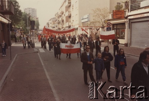 Lata 80., Włochy.
Pierwszomajowa demonstracja zorganizowana przez włoskie związki zawodowe - manifestanci z polskimi flagami na których widoczny jest napis: 