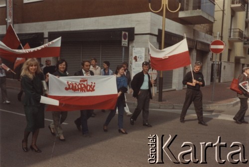 Lata 80., Włochy.
Pierwszomajowa demonstracja zorganizowana przez włoskie związki zawodowe - manifestanci z polskimi flagami, na których widoczny jest napis: 