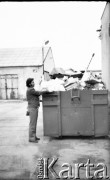 kwiecień 1981, Grudziądz, woj. toruńskie, Polska.
Mężczyzna przy kontenerze na śmieci wypełnionym 